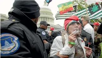  ?? REUTERS ?? Police arrest protesters smoking marijuana near the steps of the US Capitol in Washington, DC. Dealers in the city are giving the drug away as a gift with purchases of food, paintings and other goods, to get around a ban on recreation­al cannabis sales...