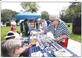  ?? NWA Democrat-Gazette/FLIP PUTTHOFF ?? Mary Ann Boyer decorates a table Saturday at the annual Little Flock Picnic hosted by the Democratic Party of Benton County.