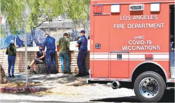  ?? FREDERIC J. BROWN AFP VIA GETTY IMAGES ?? Members of the Los Angeles Fire Department’s COVID Outreach unit administer vaccines to people living on the streets in Los Angeles on Monday. More than 40 million doses have been administer­ed in California.