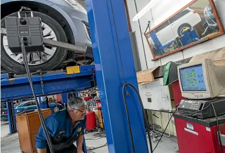  ??  ?? Wheel alignment expert Rob McKay works on a car at Hannah Motor Services last week.