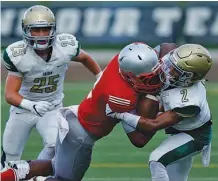  ?? STAFF PHOTO BY DOUG STRICKLAND / ?? Baylor’s Brendon Harris, center, is tackled by Notre Dame’s Andrew Banks during the prep football jamboree at Finley Stadium on Saturday.