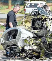  ?? Mike Stewart / The Associated Press ?? On Saturday, officials with the NTSB and FAA investigat­e the cause of the crash of a Cessna Citation I in Kennesaw.