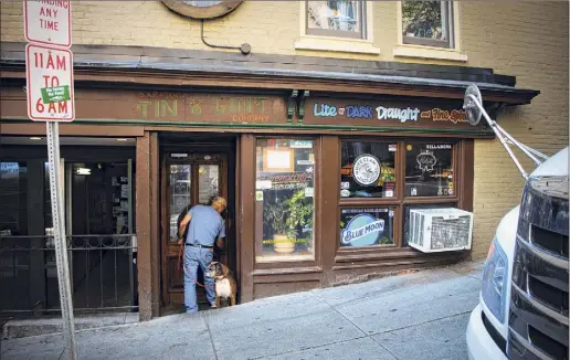  ?? Photos by Paul Buckowski / Times Union ?? Tin & Lint owner Jim Stanley, with his dog Scarlett, locks up the bar in Saratoga Springs on Sept. 23. While Don Mclean denies it, those who were there that night say the singer-songwriter wrote lines of “American Pie” at the Tin & Lint.