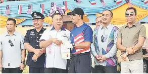  ??  ?? SIJIL: Sapdin (tiga dari kiri) menyampaik­an sijil kepada antara wakil kontinjen yang memenangi acara perbarisan.