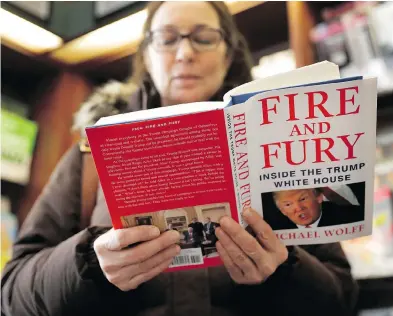  ?? CHARLES REX ARBOGAST / THE ASSOCIATED PRESS ?? Kathy Mallin looks over a copy of the book Fire and Fury: Inside the Trump White House by Michael Wolff at Barbara’s Bookstore in Chicago on Friday, the day that it went on sale.
