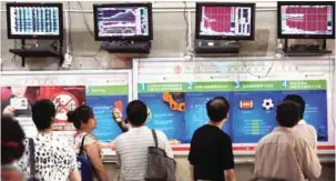  ?? —AFP ?? WUHAN: Investors monitor stock prices at a securities firm in Wuhan, in central China’s Hubei province yesterday.