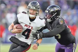  ?? Todd olszewski/Getty Images north america/Tns ?? Desmond Ridder #4 of the Atlanta Falcons carries the ball against the Baltimore Ravens during the second half of the game at M&T Bank Stadium on Dec. 24, 2022, in Baltimore, Maryland.