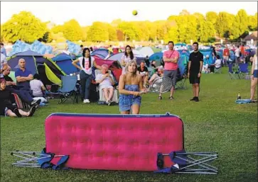  ?? Laurence Griffiths Getty Images ?? FANS USE an air mattress as a makeshift net and play tennis to kill time at the Wimbledon queue campsite.