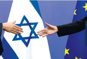  ?? AP FOTO ?? PEACE. European Union High Rep. Federica Mogherini, right, reaches out to shake hands with Israeli Prime Minister Benjamin Netanyahu after a media conference.