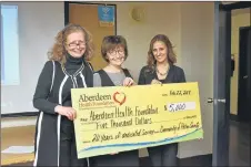  ?? SAM MACDONALD/THE NEWS ?? Robyn Eaton, left, and Kim Martin, right, with the Aberdeen Health Foundation, present a cheque of donations in honour of retiring executive director Susan Malcolm, for her legacy of work with the foundation, over 20 years.