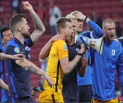  ??  ?? لاعبو المنتخب الفنلندي يحتفلون عقب الفوز التاريخي على الدنمارك