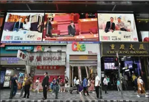  ?? (AFP) ?? A file photo shows China’s President Xi Jinping (top centre) on a large video screen in Hong Kong during a live broadcast of the National People’s Congress.