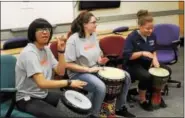  ?? MICHILEA PATTERSON — DIGITAL FIRST MEDIA ?? High school students bang on drums as part of a therapeuti­c jam session during an all-girl health and wellness summit at the Montgomery County Community College campus in Pottstown. The YWCA Tri-County Area organized the event.