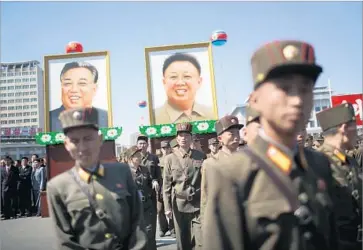  ?? Wong Maye-E Associated Press ?? SOLDIERS stand before portraits of late North Korean leaders Kim Il Sung and Kim Jong Il in Pyongyang. Authoritie­s on Saturday morning prevented a U.S. citizen from boarding a flight out of Pyongyang.
