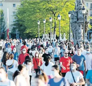  ?? JAVIER LÓPEZ / EFE ?? Nueva normalidad: numerosas personas atraviesan el puente de Toledo de Madrid, en el segundo día en que los adultos podían salir a pasear y hacer deporte en ciertas franjas horarias