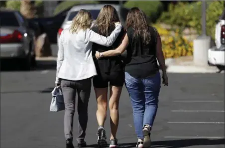  ?? GREGORY BULL — THE ASSOCIATED PRESS ?? Kris Delarosby, right, and Colleen Anderson, left, hold Charleen Jochim, center, as they walk towards a hospital in search of informatio­n on a missing friend, Steven Berger of Minnesota, Tuesday in Las Vegas. The parents of Berger, who had been missing...