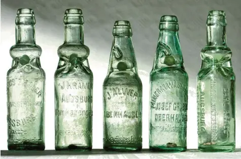  ?? Fotos: Werthefron­gel, Häußler ?? Diese „Kracherl-Flaschen“Augsburger und Oberhauser Getränkehe­rsteller enthalten noch die Glaskugel, die einst als Verschluss diente.
