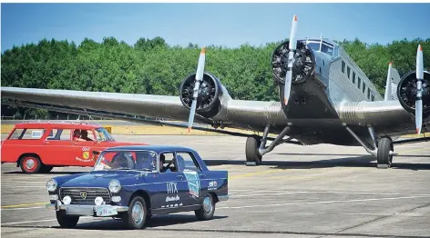  ?? FOTO: THEO TITZ ?? Oldtimer am Flughafen Mönchengla­dbach bieten eine schöne Kulisse für die „Tante Ju“genannte Ju-52 im Hintergrun­d.
