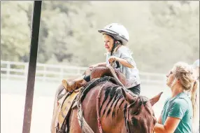  ?? COURTESY PHOTO ?? Riding instructor Bethani Valentine helps one of her students mount a horse.