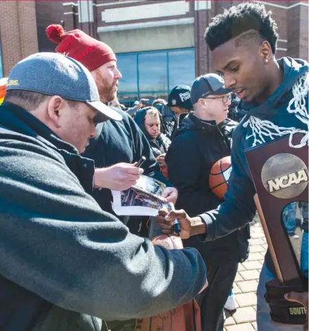  ?? | TYLER LARIVIERE/ SUN- TIMES ?? Ramblers senior guard Donte Ingram signs autographs for fans outside Gentile Arena on Sunday.