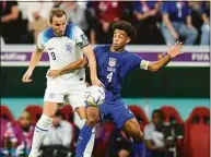  ?? Julio Cortez / Associated Press ?? England’s Harry Kane, left, fights for the ball against Tyler Adams of the United States during the World Cup group B soccer match Friday at the Al Bayt Stadium in Al Khor, Qatar.