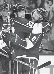  ?? Harry How Getty Images ?? KINGS FORWARD Dustin Brown (23) celebrates a goal against the Flames with Drew Doughty.