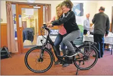  ?? 01_B36eco03 ?? Eco Savvy project manager Judith King shows Caylyn Millar how to operate the electric bicycle.