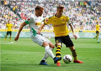 ??  ?? To no avail: Borussia Dortmund’s Marco Reus (right) shielding the ball from Borussia Moenchengl­adbach’s Louis Beyer during the Bundesliga match at the Signal Iduna Park in Dortmund on Saturday. — Reuters