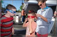  ?? NWA Democrat-Gazette/BEN GOFF • @NWABENGOFF ?? Tisha Brown of Centerton helps her sons Eli Brown (left), 10, and Jude Brown, 7, put on Teenage Mutant Ninja Turtles masks they picked up Friday while visiting booths in the Studio Lounge at the Bentonvill­e Film Festival.