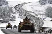  ?? AP ?? A convoy of Russian armored vehicles moves along a highway in Crimea on Tuesday. Russia has concentrat­ed an estimated 100,000 troops near Ukraine.