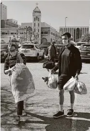  ??  ?? Alyssa Gooch helps Kaleb Starr unload his donations.