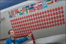  ?? (AP/Gemunu Amarasingh­e)* ?? Lt. Commander Sam Urato, a P-3 pilot of National Oceanic and Atmospheri­c Administra­tion, points to decals on the fuselage of the “hurricane hunter” aircraft representi­ng the hurricanes it has entered during a hurricane awareness tour.