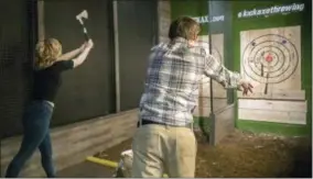  ?? MARY ALTAFFER — THE ASSOCIATED PRESS ?? In this Saturday photo, contestant­s throw hatchets at wooden bull’s-eyes at the Kick Axe Throwing venue in the Brooklyn borough of New York. Kick Axe Throwing is the first bar in New York City to pick up on a nationwide trend of ax throwing.