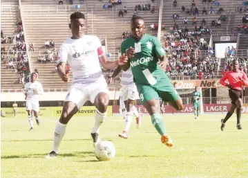  ??  ?? HUSTLE AND BUSTLE ... CAPS United striker Dominic Chungwa (right) tries to bulldoze his way past Ngezi Platinum’s defender Frank Makarati during yesterday’s Castle Lager Premiershi­p football match at the National Sports Stadium. Ngezi Platinum upset CAPS United 2-1. — Photo by Innocent Makawa