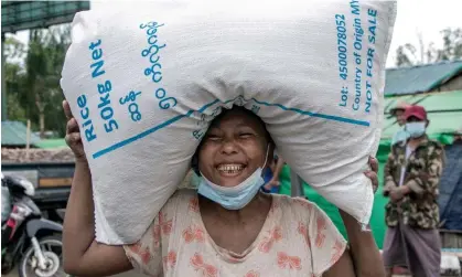  ?? Photograph: AFP/Getty ?? A woman on in Yangon, Myanmar, with a bag of rice distribute­d by the World Food Programme.