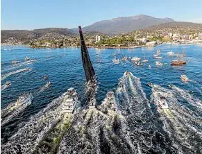  ?? AP ?? Comanche is escorted by spectator craft on arrival in Hobart.