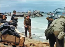  ?? HANDOUT IMAGES FROM THE GEORGE STEVENS COLLECTION AT THE LIBRARY OF CONGRESS VIA AP ?? ABOVE: Soldiers and landing craft are seen on the beach during D-Day operations on June 6, 1944 in France.
BELOW: British naval gun crewmen wearing protective hoods and gloves are surrounded by empty shell casings on the deck of a ship off the coast of France on D-Day, June 6, 1944. BOTTOM: U.S. troops drive through a French town during the Second World War.