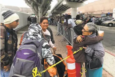  ?? Elliot Spagat / Associated Press 2019 ?? Luz Bertila Zazueta, 75, hugs a Peruvian family in Tijuana whose number was called to claim U.S. asylum.