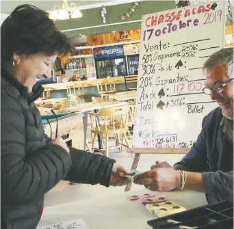  ??  ?? Les bénévoles de la Chasse à l’as de pique de Saint-Simon ne chôment pas en cette dernière semaine de loterie. Ginette Albert, de Caraquet, achète ses billets des mains de Luc Lanteigne. - Acadie Nouvelle: Réal Fradette