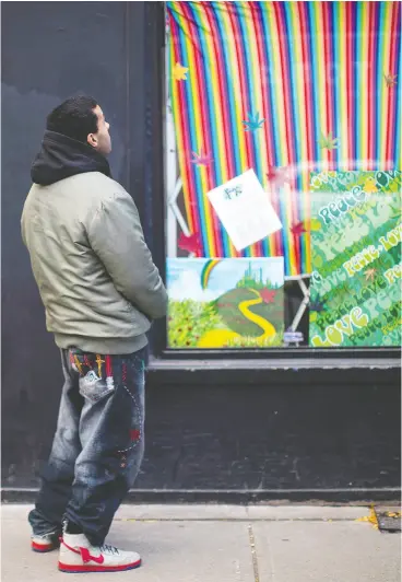  ?? CHRIS YOUNG / THE CANADIAN PRESS ?? Jeffrey Grady, a former employee of cannabis dispensary Peace and Love, stands outside the shuttered store in Toronto as legalizati­on took effect in 2018.