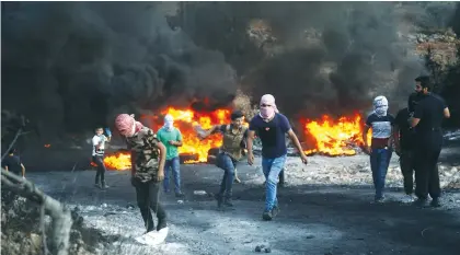  ?? (Nasser Ishtayeh/Flash90) ?? SECURITY FORCES clash with Palestinia­n protesters during a protest near Nablus yesterday against the Evyatar outpost.