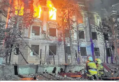  ?? EFE ?? Un edificio ucraniano arde ante la mirada de los bomberos.