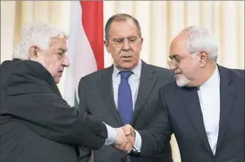  ?? Pavel Golovkin/Associated Press ?? Russian Foreign Minister Sergey Lavrov, center, stands as Syrian Foreign Minister Walid Muallem, left, and Iranian Foreign Minister Mohammad Javad Zarif shake hands Friday after a shared news conference following their talks focused on Syria in Moscow.