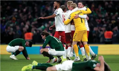  ??  ?? Denmark celebrate reaching Euro 2020 as the Republic of Ireland players hit the floor in disappoint­ment. Photograph: Niall Carson/PA