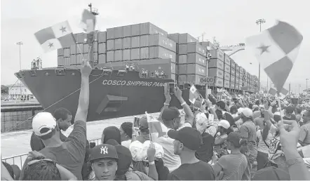  ?? Rodrigo Arangua / AFP / Getty Images ?? Thousands cheer Sunday as a Chinese-owned cargo ship become the first to cross the new Cocoli locks at the Panama Canal.