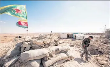  ?? Ahmet Sik Getty I mages ?? A KURDISH FIGHTER at a checkpoint on the outskirts of Kobani, Syria, near the Turkish border. Kurdish f ighters ousted Islamic State militants from Kobani and, more recently, Tal Abyad, another frontier town.