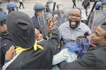  ?? CHIP SOMODEVILL­A / GETTY IMAGES ?? A man shouts for calm Monday as protesters clash with Baltimore police at the corner of Pennsylvan­ia and North avenues in the city as angry demonstrat­ions broke out following the funeral of Freddie Gray.