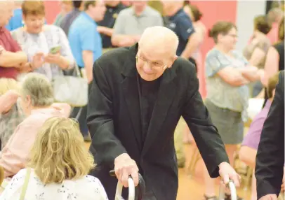  ?? JEFF VORVA/DAILY SOUTHTOWN PHOTOS ?? The Rev. Albert Adamich meets and greets people during a reception in the Most Holy Redeemer gym in Evergreen Park on Sunday after he celebrated Mass on his 100th birthday.