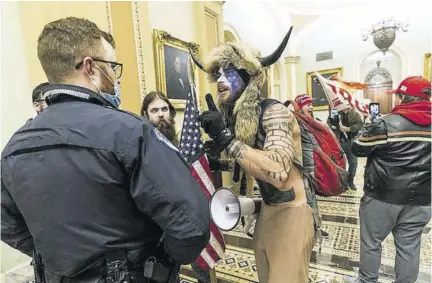  ?? (Photo: AP) ?? In this January 6, 2021 file photo, supporters of President Donald Trump are confronted by US Capitol Police officers outside the Senate Chamber inside the Capitol in Washington. An Arizona man seen in photos and video of the mob wearing a fur hat with horns was also charged Saturday in Wednesday’s chaos. Jacob Anthony Chansley, who also goes by the name Jake Angeli, was taken into custody Saturday.