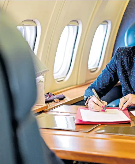  ??  ?? Theresa May signs her ‘letter to the nation’ as she heads to Brussels yesterday